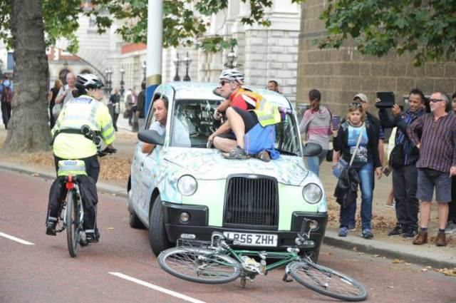 Angry bicyclist jumps on the hood of the car he cut off.